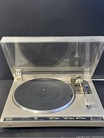 Front view of the vintage JVC turntable with clear dust cover opened, showing platter and tonearm.