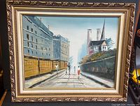 Front view of the framed vintage oil painting showing the city street scene with pedestrians and buildings.