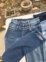 Variety of women's jeans and jeggings in multiple washes and distress styles.