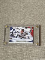Close-up image of James Reimer hockey card inside a clear protective case showing the goalie in action.