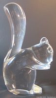 Front side view of clear crystal squirrel paperweight showing its shape, tail and paws.