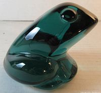 Side perspective showing the smooth, polished green crystal frog with defined eyes and body contours.