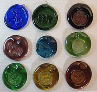 Photo of nine pressed glass figural sun catchers in various colors showing animal designs.