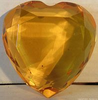 Top view of the yellow faceted heart-shaped crystal paperweight showing its shape and color.