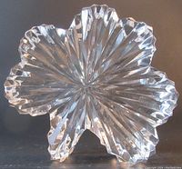 Front view of the clear crystal clover-shaped sculptured paperweight showing intricate faceted design and beveled edges.