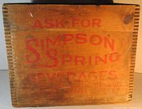 Front side of wooden box showing red stenciled text 'ASK FOR SIMPSON SPRING BEVERAGES'.