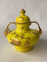 Front-right angle view of vase showing yellow ground and gilt floral design