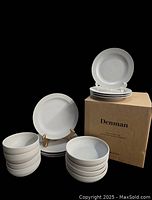 Full view of the 16 piece Denman dish set by Urban Barn in stoneware with matte reactive glaze and gloss spray finish. Four stacks each with four pieces: large plates, small plates, large bowls, small bowls plus original box.