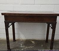 Front view of folded tea table against white brick wall