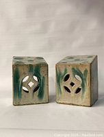 Two glazed ceramic antique Chinese headrests with slant tops and pierced decoration on front face