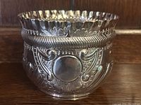 Front view showing scalloped rim, rope twist band and blank circular cartouche