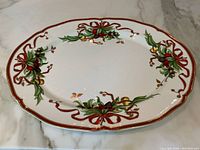 Full top view of oval platter showing holiday ribbon and foliage motif