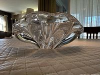 Image showing side view of the clear art glass bowl with its organic wave shape and bubble pattern inside.