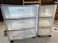 Front angle view of both rolling storage chests showing drawer fronts and caster wheels