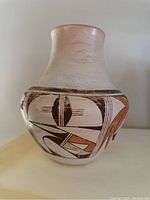 Front view of jug showing buff slip body with black and brown geometric designs