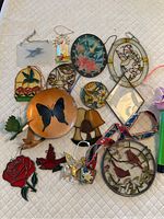 Photo showing full assortment of stained glass and hanging ornaments with nature themes, including birds, flowers, and butterflies.