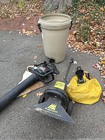 Overview of Toro blower, McCulloch vacuum, yellow bags, and tan trash tote on asphalt.