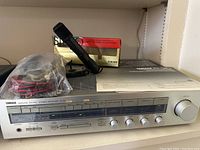 Yamaha R-30 stereo receiver with plastic-covered cables and Sony ECM-909 microphone and box on shelf.