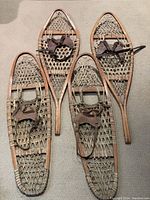 Four wooden snowshoes laid flat showing full lot