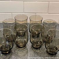 Set of 8 Dominion Glass medium-sized tulip-shaped tumblers in tawny smokey color, displayed on a countertop.