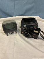 Full view of black Ansco 105 camera with flash, leather case, and grey Eddie Blacks slide viewer on cloth background.