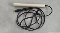Silver AKAI ADM-60 dynamic microphone showing full length including attached cable with 3.5mm plug