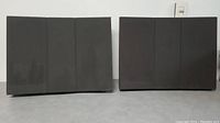 Front view of two black Bang & Olufsen Model 6503 speakers with fabric covers and vertical panel divisions