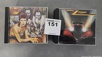 Two CDs shown side by side: Diamond Dogs by David Bowie and Eliminator by ZZ Top, with minor wear visible on cases.