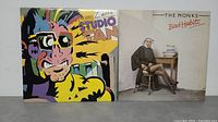 Two vinyl record albums: Frank Zappa's Studio Tan and The Monks' Bad Habits, placed side by side showing album covers clearly.