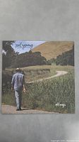 Front cover of Neil Young's 'Old Ways' vinyl album featuring person walking on path with natural rural background.