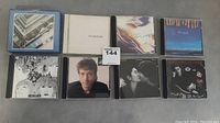 Overview of all 8 CDs arranged in two rows showing the cover art including Beatles, John Lennon, and Paul McCartney albums.