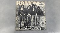 Front album cover showing black and white photo of the Ramones band members in leather jackets against a graffiti background with large RAMONES text.