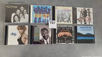 Eight CD cases laid out flat showing cover art for The Platters, Four Tops, The Ventures, and others.