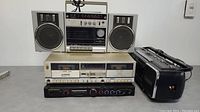 Lot of 4 vintage stereo electronic items displayed together including 2 Toshiba cassette players and Marantz karaoke amplifier on table.
