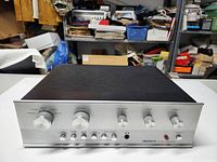 Front panel view showing silver aluminum faceplate with Dynaco logo, five control knobs (volume, input selector, bass, treble, balance), headphone jack and power indicator