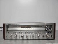 Front view showing tuning dial, dual VU meters, control knobs and wood side panels