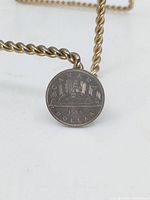 Reverse side of 1986 Canadian coin featuring five sailing ships and inscriptions indicating denomination and year.