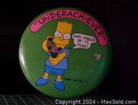 Front of pinback button showing Bart Simpson with 'Underachiever' text and signature by Matt Groening