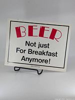 Full front view of vintage vinyl sign with the red and black text on white background.