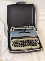 Top view of Electra 210 typewriter inside hard case showing keyboard layout and case interior.