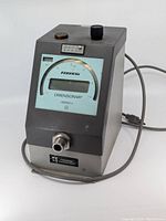 Front view of Federal Dimensionair air comparator gauge showing the dial, control knob, and front connection port with attached power cord.