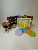 Mattel toy record player with 5 colorful music discs and house playset components in background
