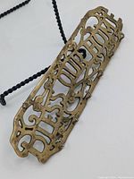 Close-up angled view focusing on the brass material and one slightly loose hanger knob.