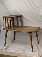 Angle showing the side table with upper and lower levels, spindle supports, and tapered legs.