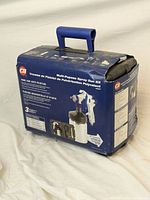 Blue plastic carrying case with handle and original Campbell Hausfeld packaging showing some wear.