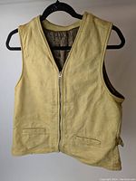 Front view of tan leather vest, showing zipper closure and welt pockets.