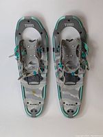 Full view of both Tubbs snowshoes showing camo pattern and frame color