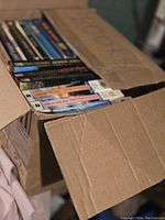 Open box showing several science fiction and fantasy paperback books packed inside, with visible colorful spines.