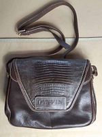 Front view of the brown leather Lanvin purse showing textured flap with embossed Lanvin branding and adjustable shoulder strap.