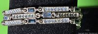 Close-up image of the three-strand bracelet shows the arrangement of blue rectangular stones alternating with multiple small clear stones on silver-tone metal links.